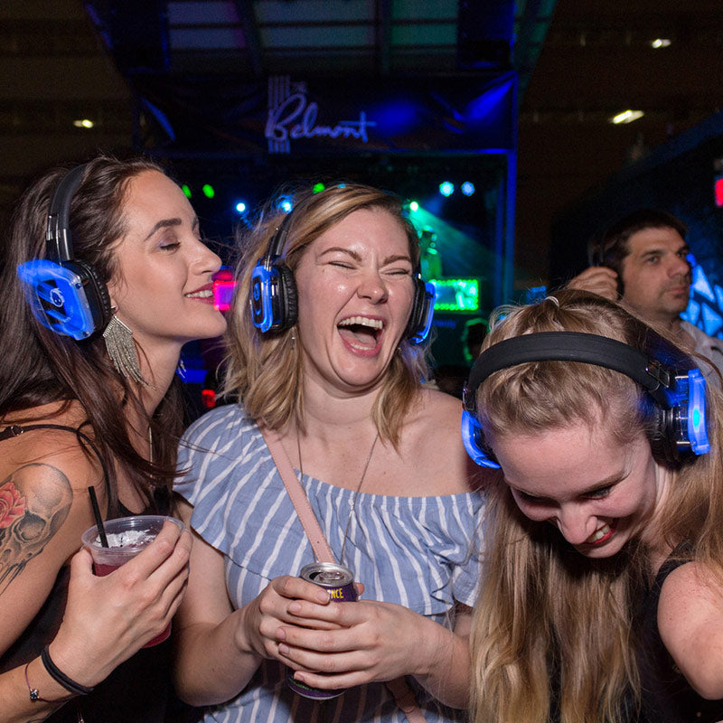 Quiet Events Silent Disco headphones for dance parties a group of college girls on a dance floor having fun and dancing with headphones