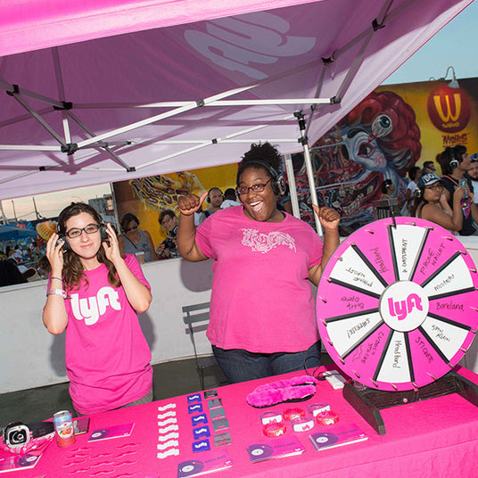 Quiet Events Silent Disco headphones for festivals two young women happy and cheering with giveaways from Lyft
