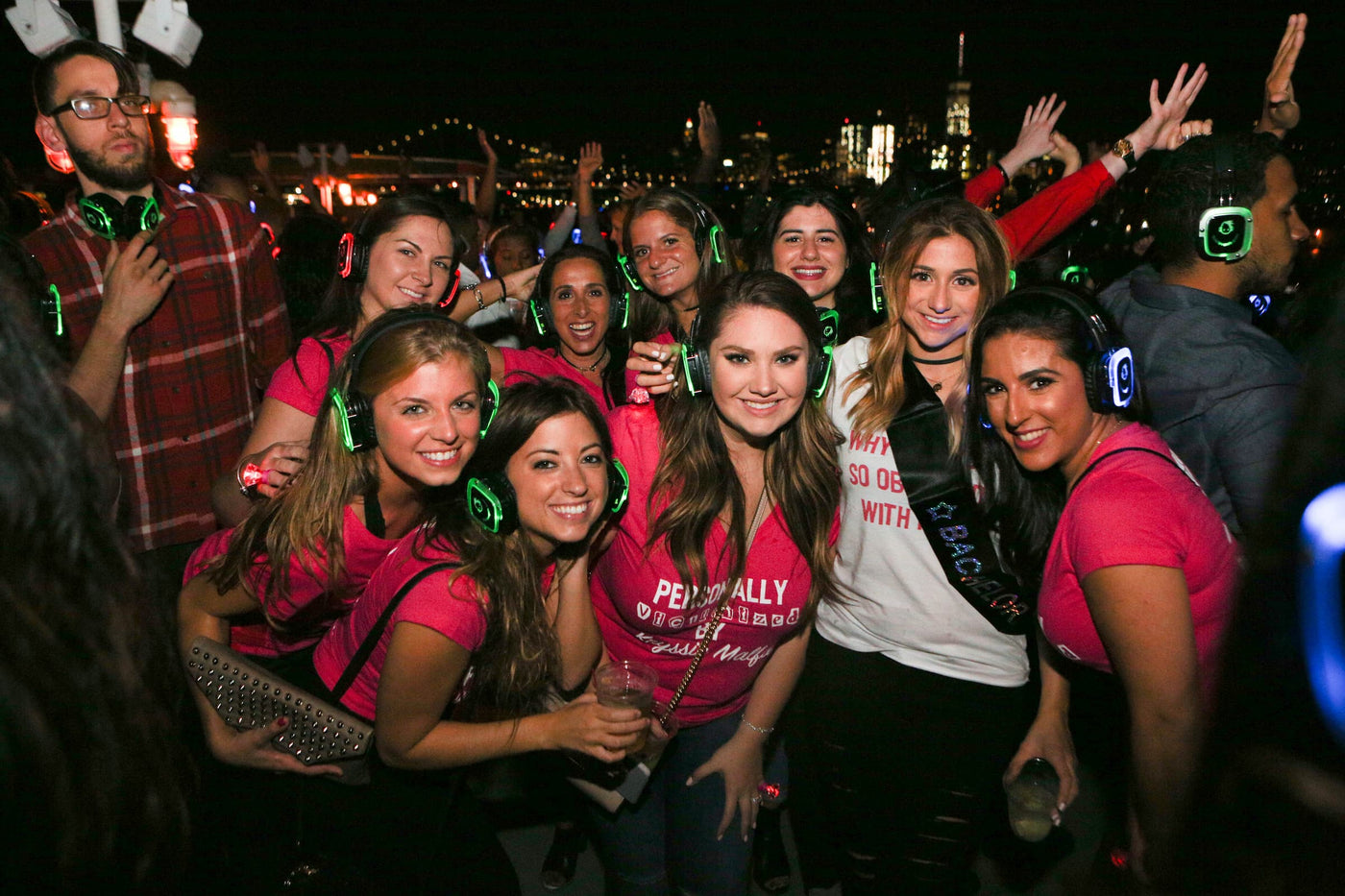 Quiet Events Silent Disco headphones for bachelorette parties. A group of girls celebrating and having fun on a night out wearing headphones.