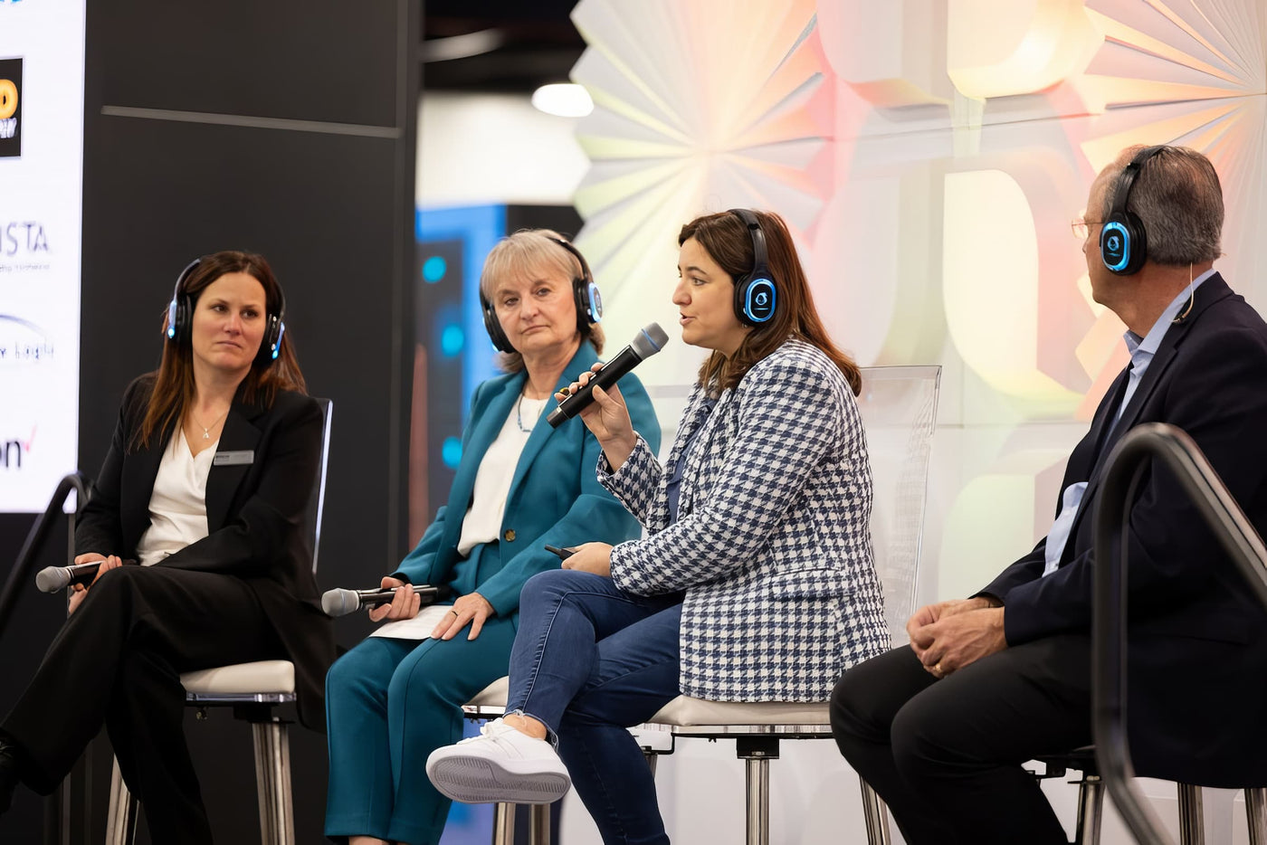 Quiet Events Silent Disco headphones for translation a panel of four people with headphones as speakers.