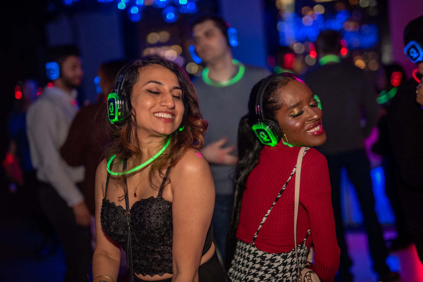 Quiet Events Silent Disco headphones for walk events. Set of of girls having fun and dancing wearing headphones.