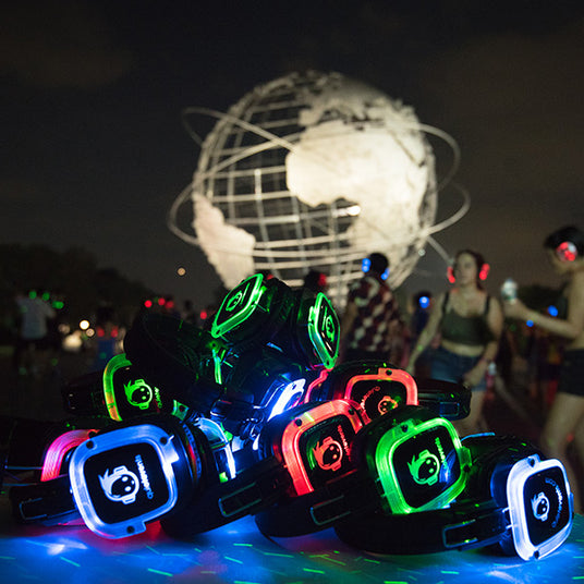 Quiet Events Silent Disco headphones for home and at a park a group of headphones piled up together and a large Sphere in the background