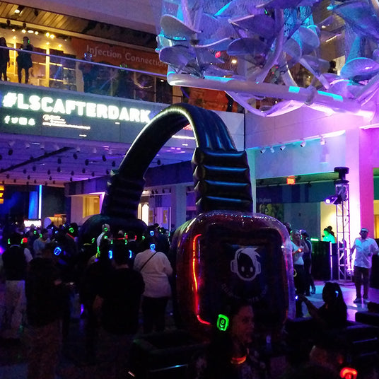 Quiet Events Silent Disco headphones for museums. A group of people under a large headphone float having fun, dancing and enjoying their time.