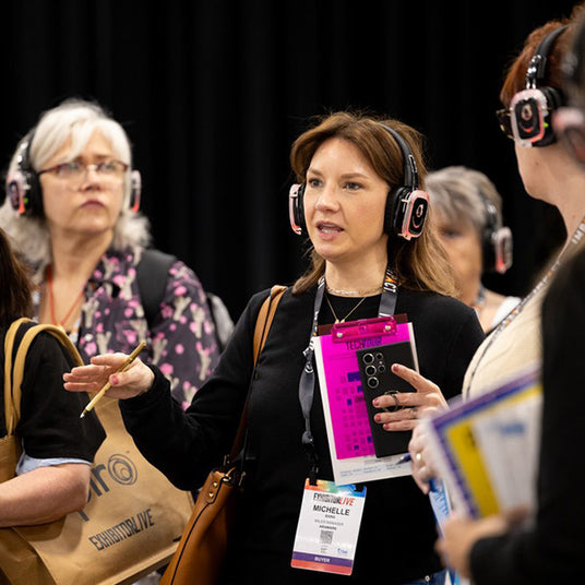 Silent Disco headphones for other quiet events. Women wearing headphones and paying attention to a particular speaker.