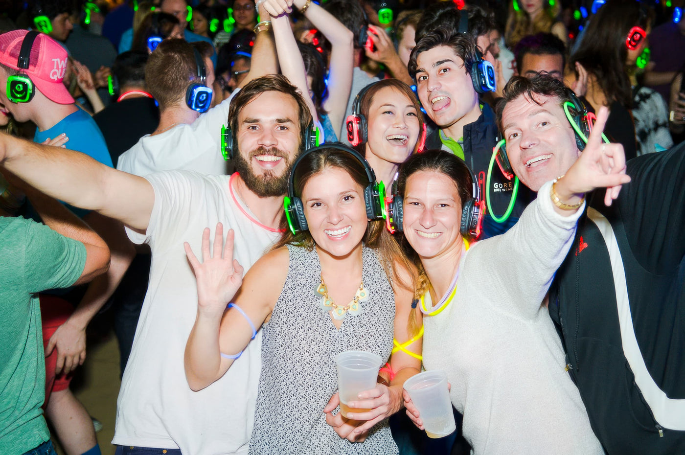 Quiet Events Silent Disco headphones for dance parties a group of people having fun and posing for a picture with  headphones on