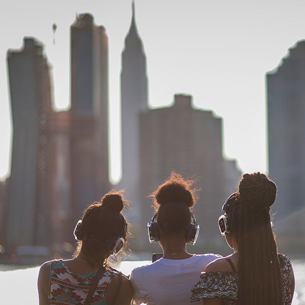 Quiet Events Silent Disco headphones for dance parties a group of girls wearing headphones and checking out the skyline of NYC