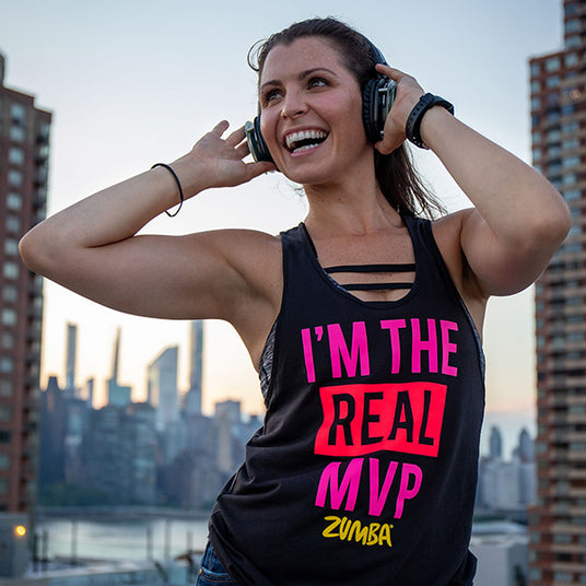 Quiet Events Silent Disco headphones for fitness and meditation.  A zumba instructor having fun outdoors holding her headphones.