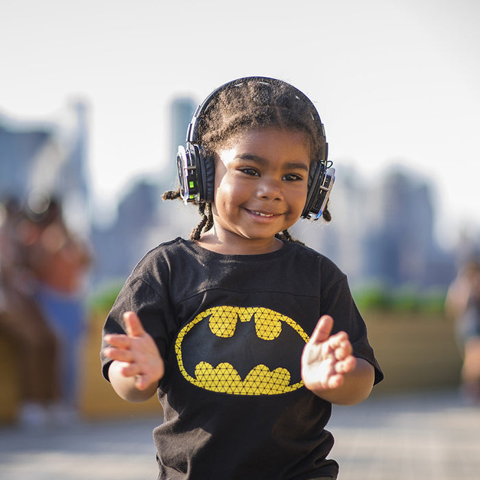 Quiet Events Silent Disco headphones for kids. A small african american child having fun listening to music with headphones.