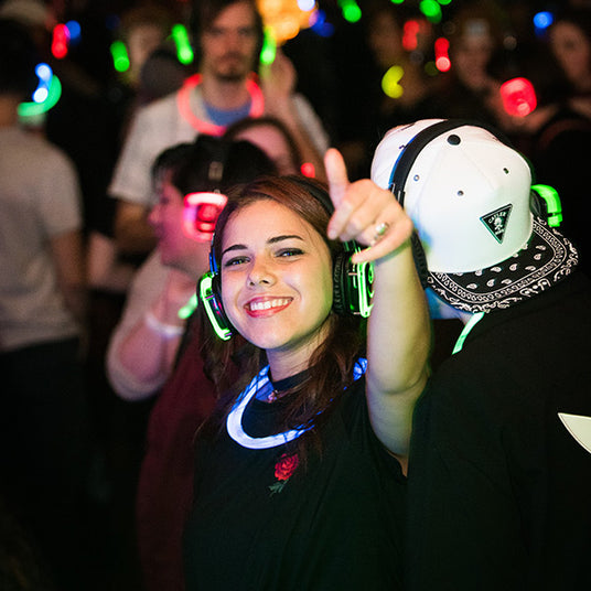 Quiet Events Silent Disco headphones for run walks.  A girl giving a camera a thumbs up wearing headphones.