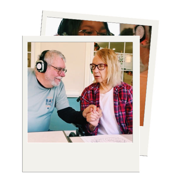 Quiet Events Silent Disco headphones for senior care.  A senior couple holding hands enjoying their company and wearing headphones.