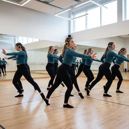 Dance team rehearsing in sync wearing wireless silent practice headphones in a quiet warm-up room